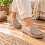 Stone suede fleece-lined moccasin slippers worn on feet with rubber outsole