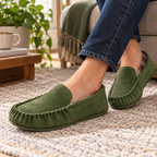 Olive plaid-lined moccasin slippers worn by a man with jeans