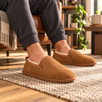 Men’s chestnut suede slippers with fluffy shearling lining, worn with trouser cuffs