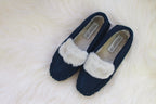 Pair of navy moccasin slippers with cream plush lining and suede upper